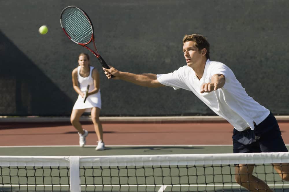 Mixed Doubles Player Reaching For Ball